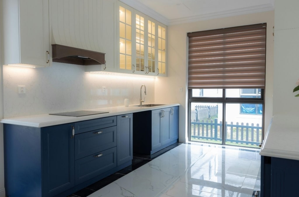 Painter spraying cabinet doors in controlled workspace during kitchen update