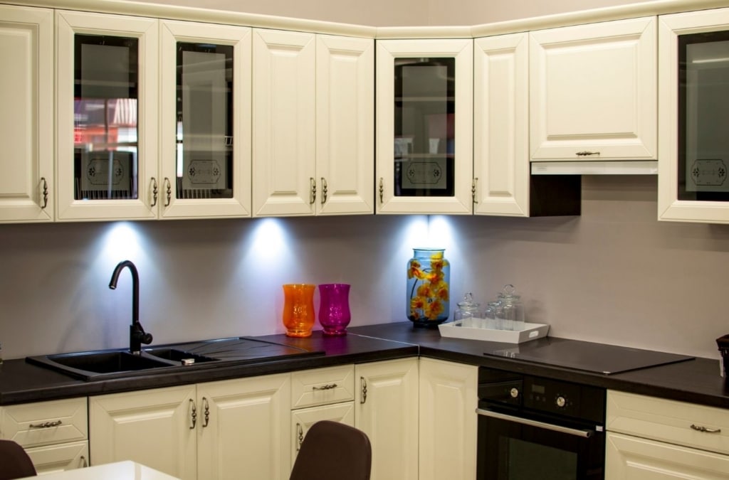 Skilled painter sanding cabinet fronts evenly for smooth durable finish. Cabinet Painting near me.