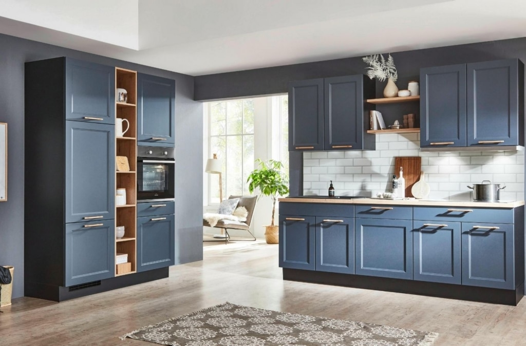 Painter reinstalling freshly finished cabinet doors in updated family kitchen
