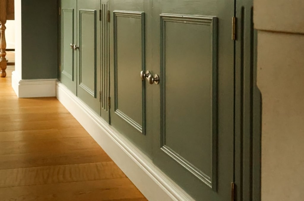 Cabinet Painting in Parker - CO in progress as a painter sprays primed cabinet doors on drying racks